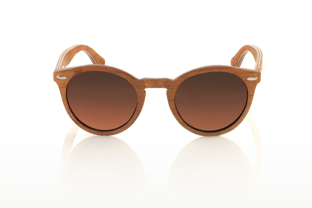 Wood eyewear of Cherry LINDA. The LINDA wooden sunglasses come with a rounded and elegant silhouette, standing out for their cross-laminated cherry wood frame, which not only guarantees durability but also a unique style thanks to its beautiful grain. Silver metal pins on the front add a touch of class, balancing the warmth of the wood with a subtle shine. With tighter measurements of 140x49 and a caliber of 48, these glasses offer a comfortable fit and versatile style, perfect for those looking for a sophisticated and timeless accessory. for Wholesale & Retail | Root Sunglasses® 